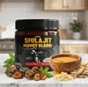 Shilajit Honey Blend container with shilajit pieces, honey, and leaves on a marble surface.