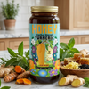 Jar of Honey Herbal Blend Turmeric supplement on a kitchen counter with turmeric roots and honeycomb.