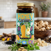 Jar of honey with a colorful label on a kitchen counter, surrounded by ginger and other ingredients.