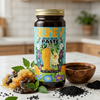 Jar of honey black seed paste on a kitchen counter with ingredients around